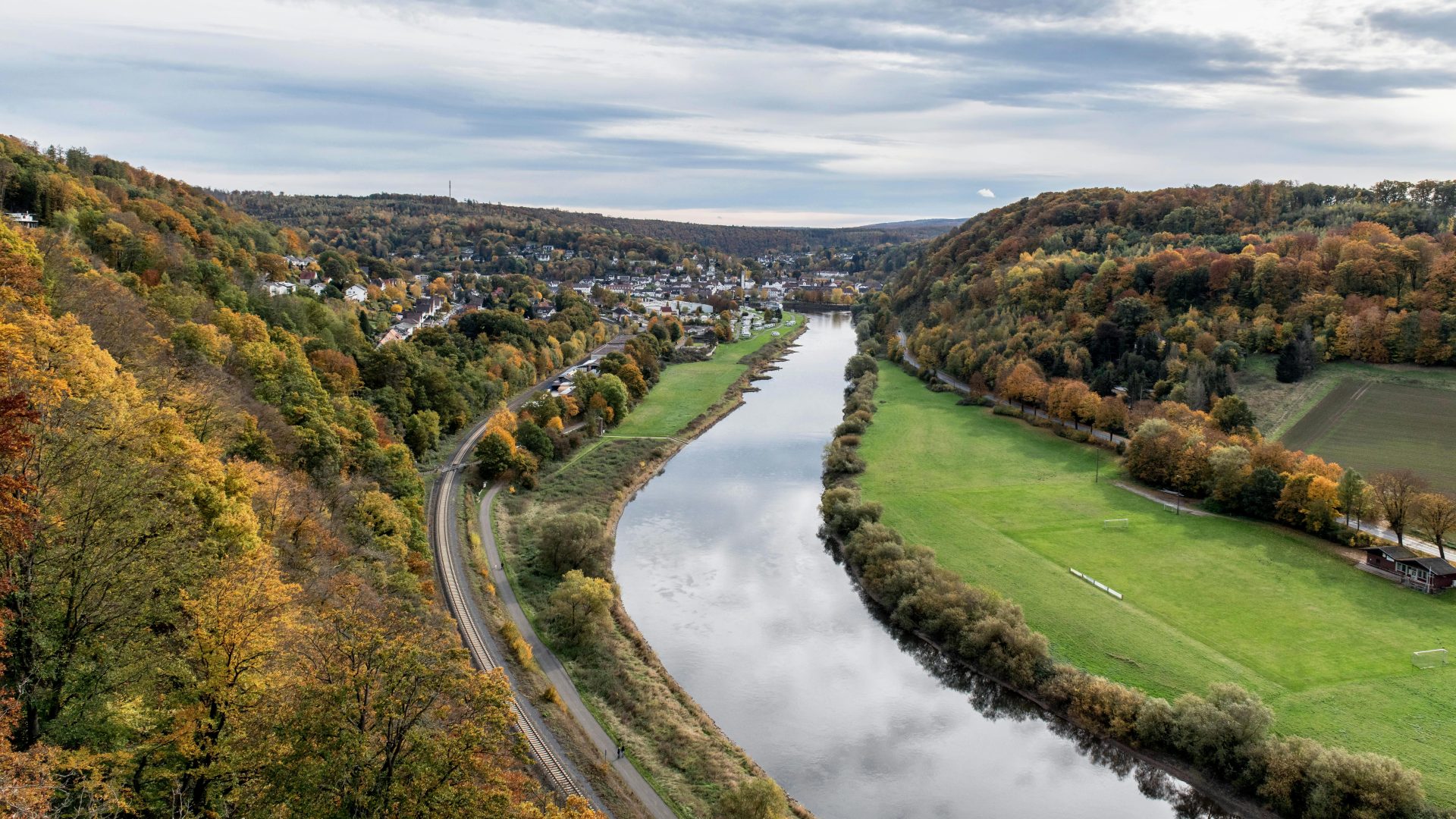 Luftaufnahme der Weser und einer farbenprächtigen Herbstlandschaft in Deutschland.